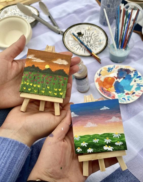 una pareja mostrando sus pinturas en miniatura